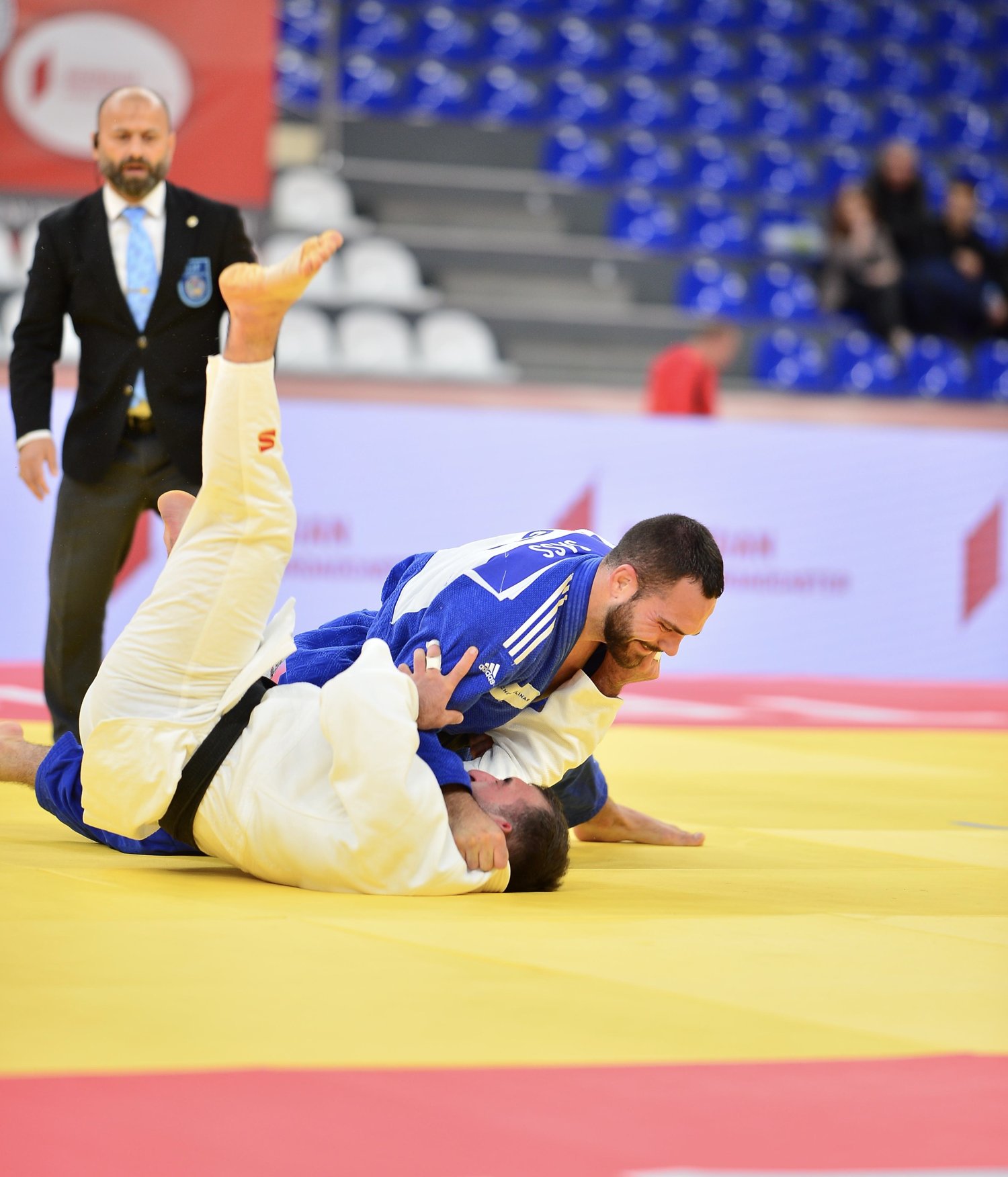 Lennart Sass in a blue judogi throws his opponent for ippon in competition.
